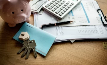 Elementos clave al tomar un crédito hipotecario en Chile: calculadora, documentos financieros, llaves y alcancía.