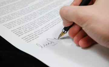 Persona firmando una escritura de propiedad